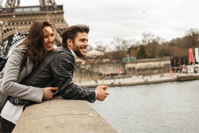 Two people smiling in front of the Eiffel Tower