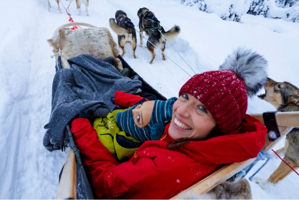 A mother and child sitting on a sled in Lapland