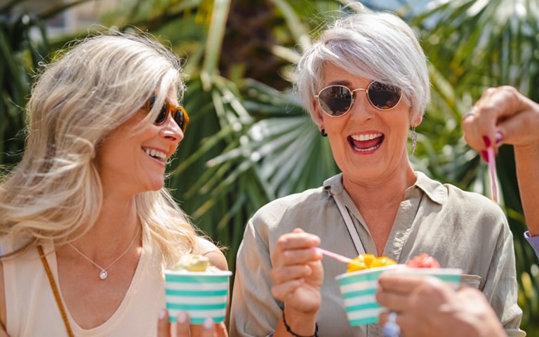 Senior women smiling and laughing while eating gelato