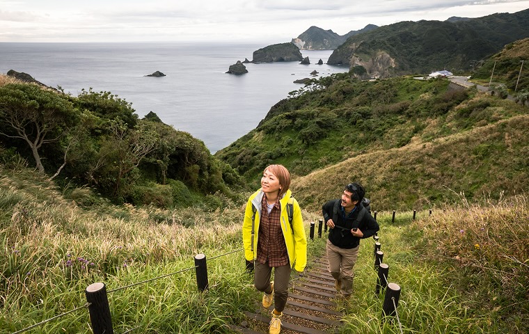 A couple enjoying a hike on a cape they visited on vacation