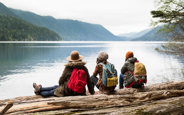 A woman and two children smiling on a rollercoaster
