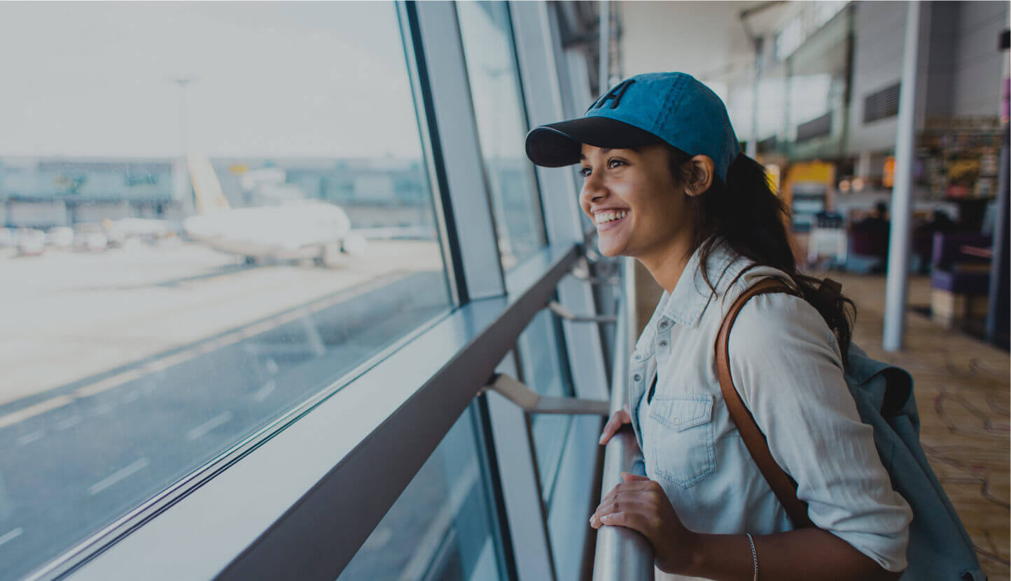 A traveller looking out the window of an airport